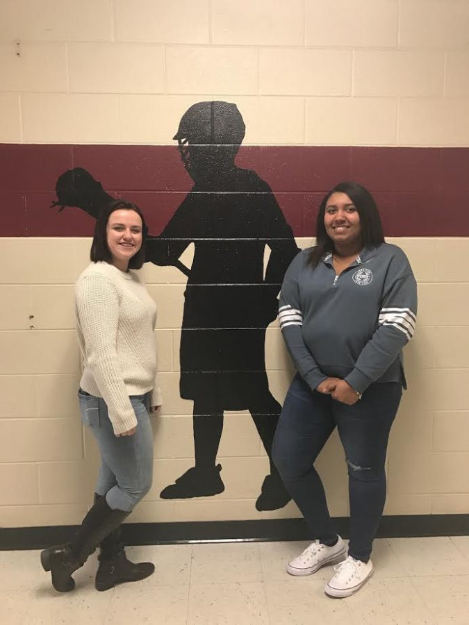 Adriana Janack and Bridget Buckley standing in front of one of their murals. 