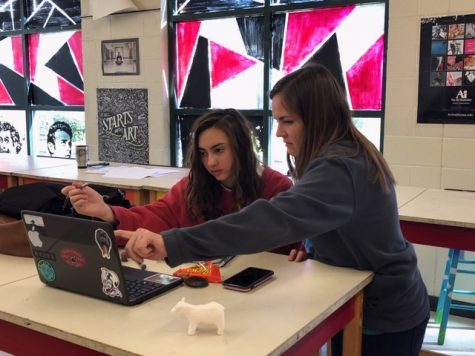Jina Manfrellotti listens to Ms. Dutka's advice about her piece on the computer.